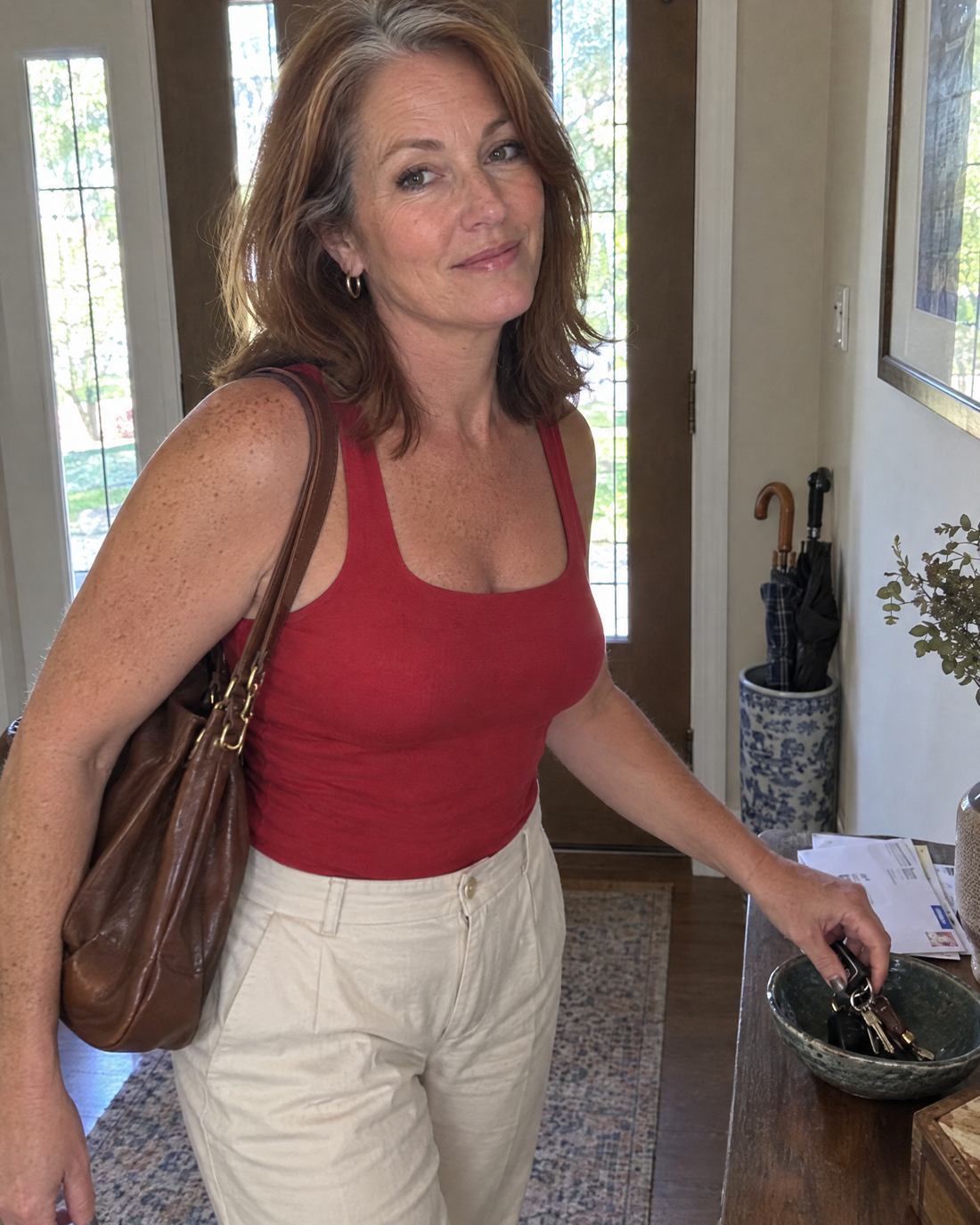 Woman in a red tank grabbing her keys on the way out in the morning