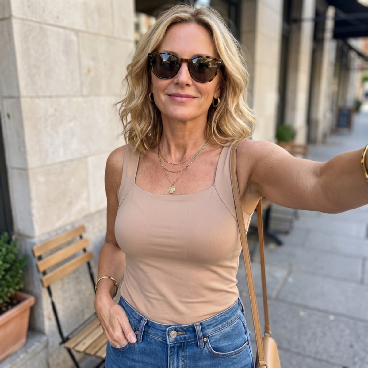 Woman wearing the tank on its own with jeans outside, square neckline
