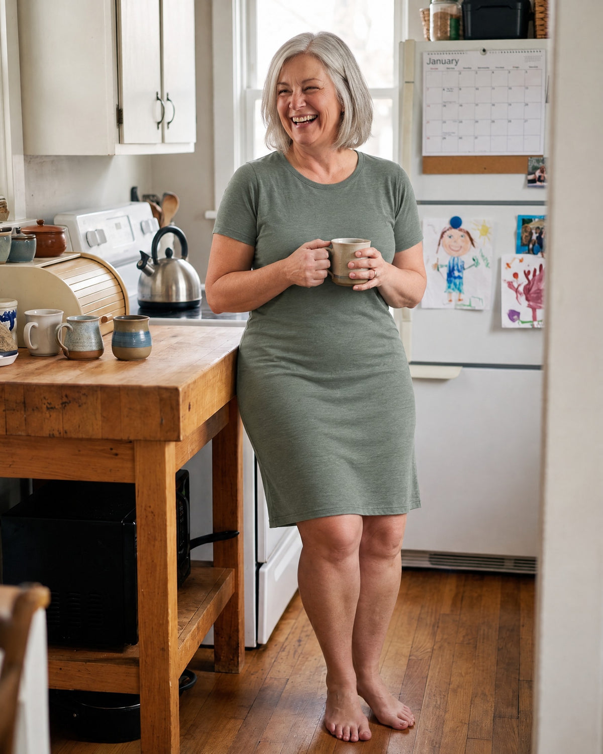Woman in a soft green dress with coffee in her kitchen, comfortable all day