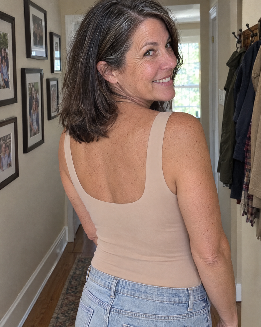 Customer looking over her shoulder, smooth back in a nude tank